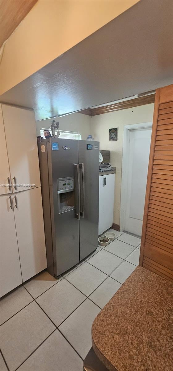 kitchen with light tile patterned flooring and stainless steel fridge