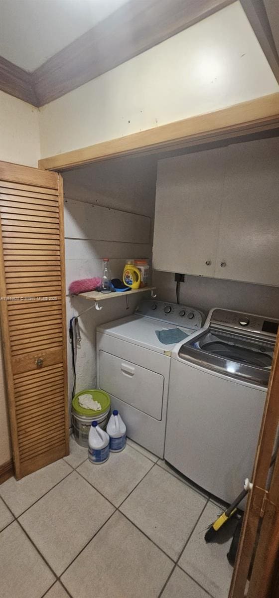 washroom with light tile patterned floors and washing machine and clothes dryer