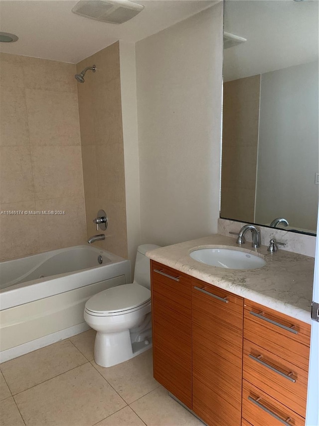 full bathroom featuring tiled shower / bath combo, tile patterned floors, toilet, and vanity