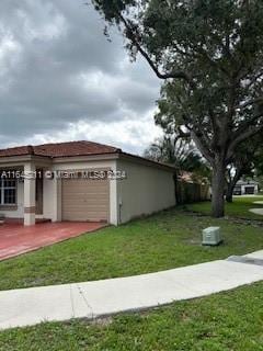 view of front of property featuring a front yard and a garage