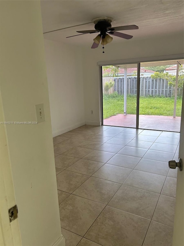 tiled spare room featuring ceiling fan