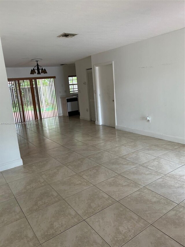 9136 NW 192nd Ter, Hialeah, FL 33018 - unfurnished room with light tile patterned floors and a chandelier