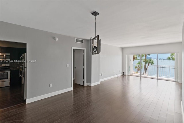 unfurnished living room featuring dark hardwood / wood-style flooring and a chandelier