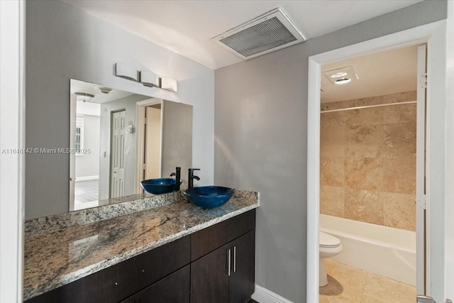 full bathroom featuring tile patterned flooring, vanity, toilet, and tiled shower / bath combo