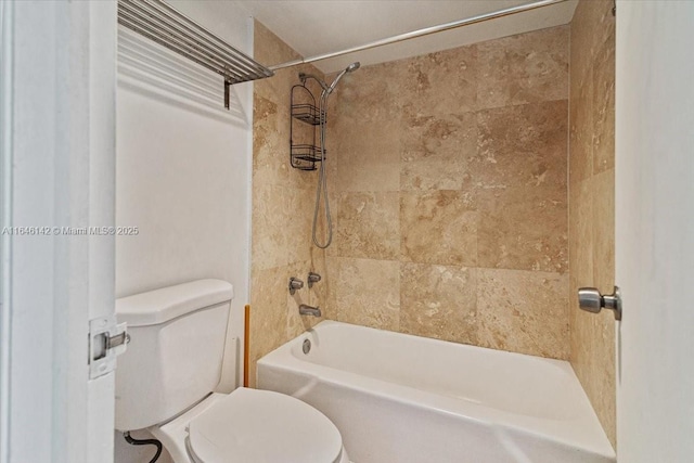 bathroom featuring tiled shower / bath combo and toilet