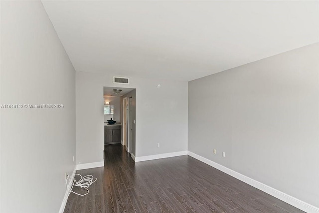 unfurnished room with dark wood-type flooring