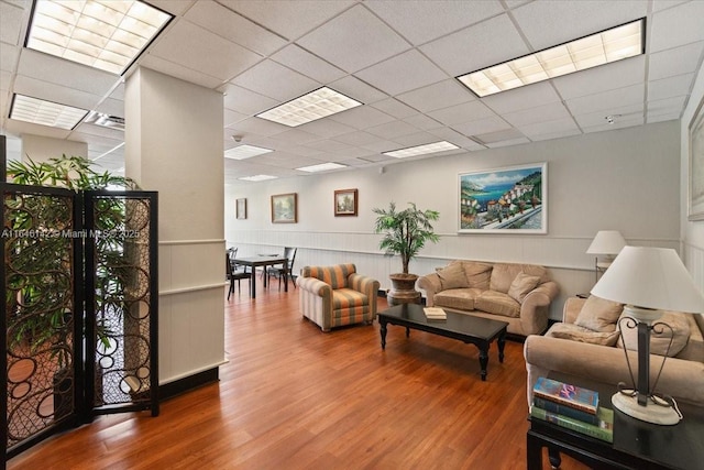 living room with a paneled ceiling and wood-type flooring