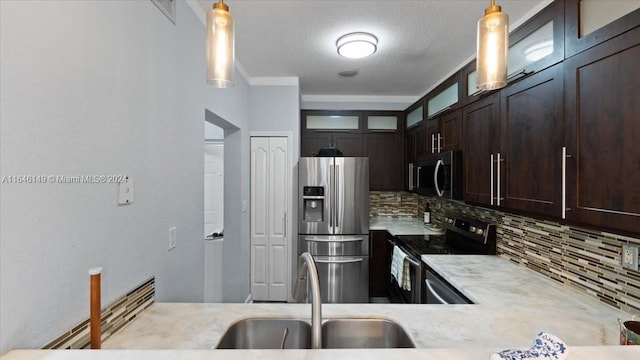 kitchen featuring backsplash, sink, appliances with stainless steel finishes, dark brown cabinetry, and pendant lighting