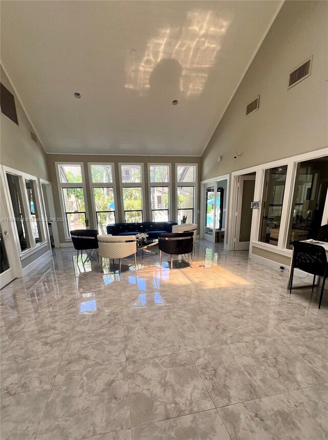 living room with tile patterned flooring, high vaulted ceiling, and french doors