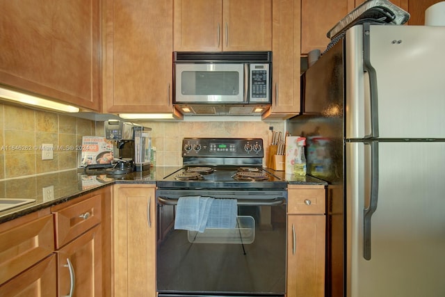 kitchen featuring appliances with stainless steel finishes, tasteful backsplash, and dark stone countertops