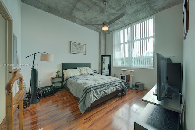 bedroom with dark hardwood / wood-style flooring and ceiling fan