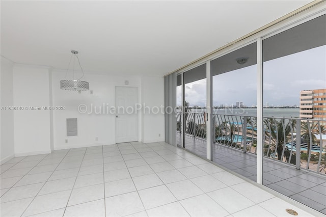 tiled empty room featuring a wall of windows and a water view