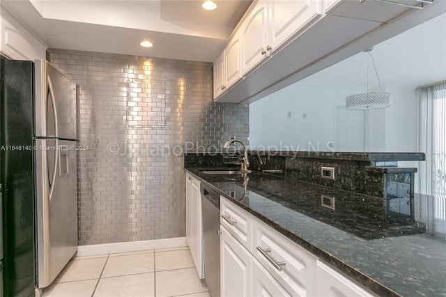 kitchen with dark stone countertops, white cabinets, stainless steel appliances, and light tile patterned floors