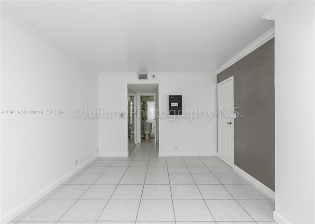 tiled spare room with ornamental molding