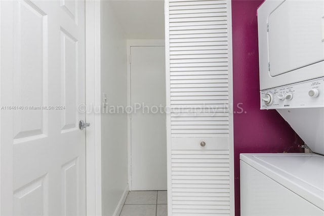 clothes washing area with light tile patterned floors and stacked washer / drying machine