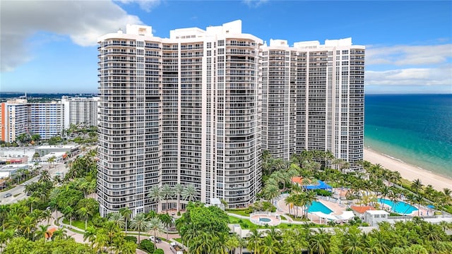 view of building exterior with a water view and a view of the beach