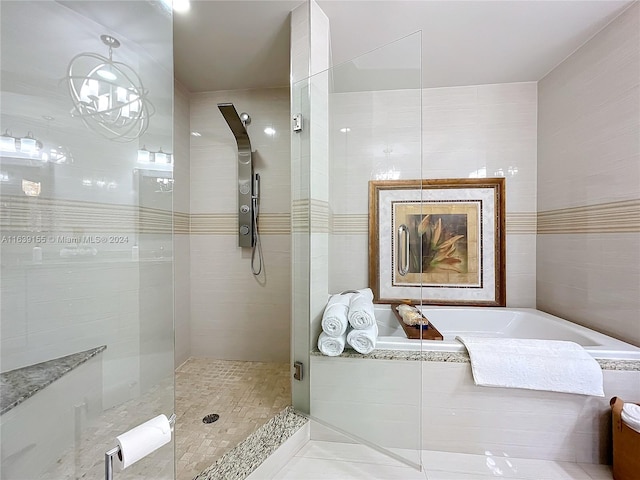 bathroom featuring independent shower and bath, tile patterned flooring, and tile walls