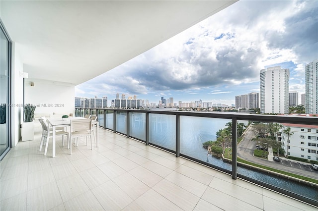 balcony featuring a water view, a view of city, and outdoor dining area