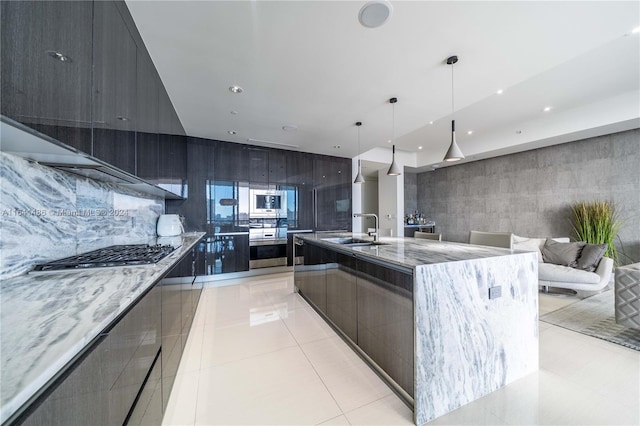 kitchen featuring a spacious island, a sink, appliances with stainless steel finishes, modern cabinets, and pendant lighting