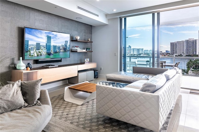 living room with a water view, light tile patterned floors, visible vents, and a wall of windows