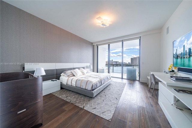 bedroom with floor to ceiling windows, dark wood finished floors, visible vents, and access to exterior