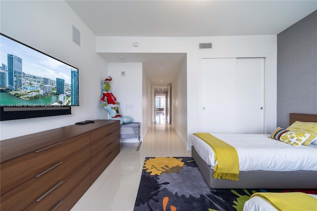 bedroom featuring a closet, visible vents, and light tile patterned floors