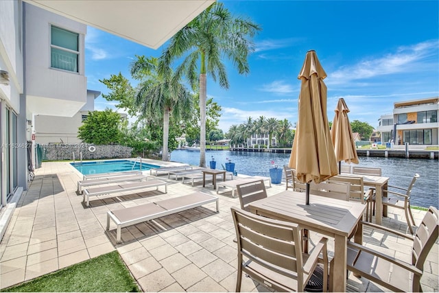 view of swimming pool featuring a patio area and a water view