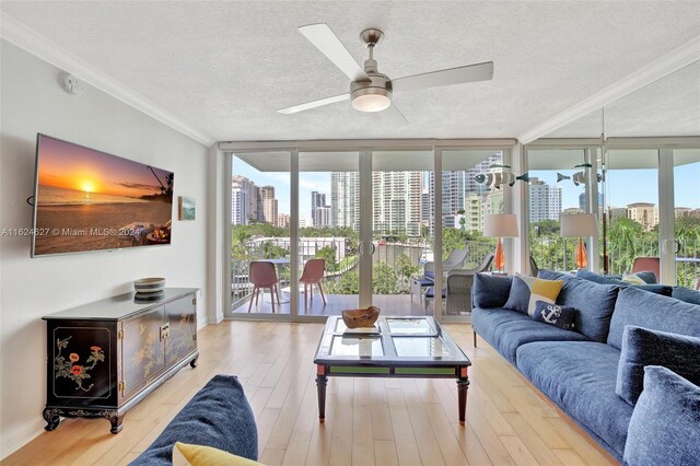 living room featuring light wood-type flooring, plenty of natural light, and a wall of windows