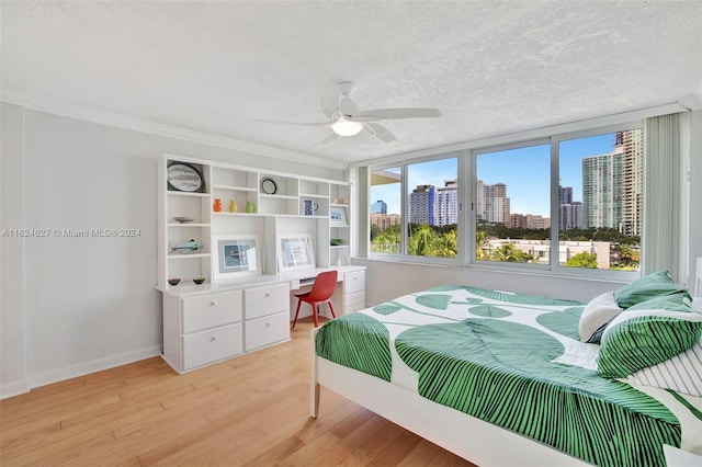 bedroom with ceiling fan, light hardwood / wood-style flooring, and a textured ceiling