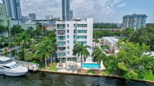 view of building exterior featuring a community pool and a water view