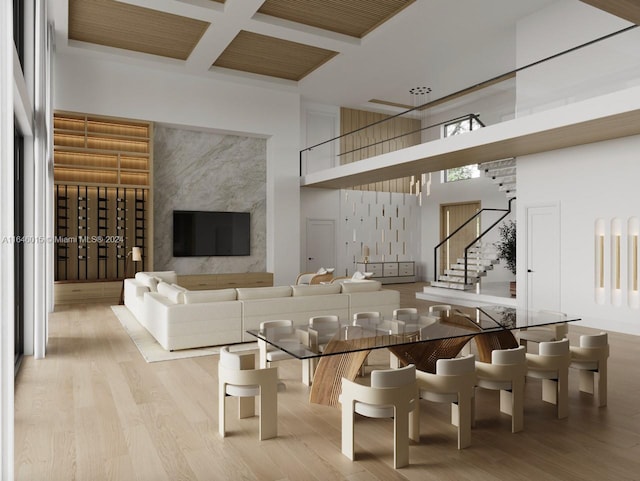 living room with a towering ceiling, coffered ceiling, and light hardwood / wood-style floors