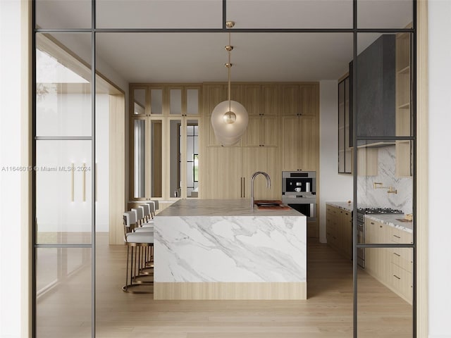 kitchen featuring light hardwood / wood-style flooring, stainless steel appliances, sink, pendant lighting, and tasteful backsplash