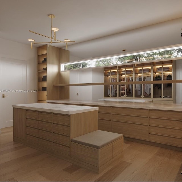 kitchen featuring a notable chandelier, light hardwood / wood-style floors, and plenty of natural light