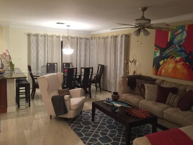 living room with ceiling fan and crown molding