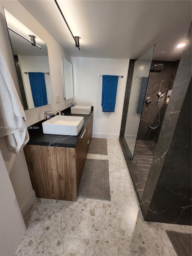 bathroom with a tile shower and vanity