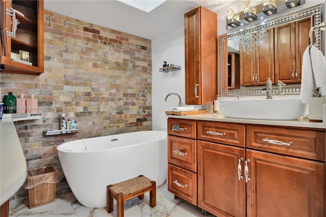 bathroom featuring vanity, a skylight, and a tub