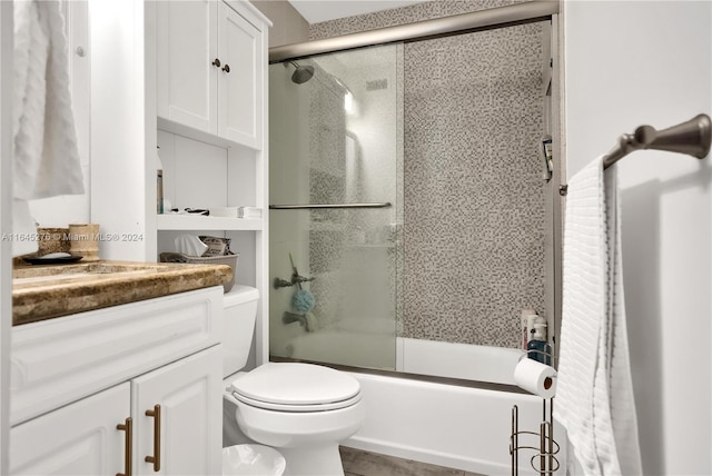 full bathroom featuring toilet, combined bath / shower with glass door, and vanity