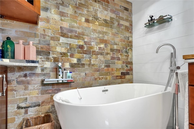 bathroom with brick wall and a bathing tub