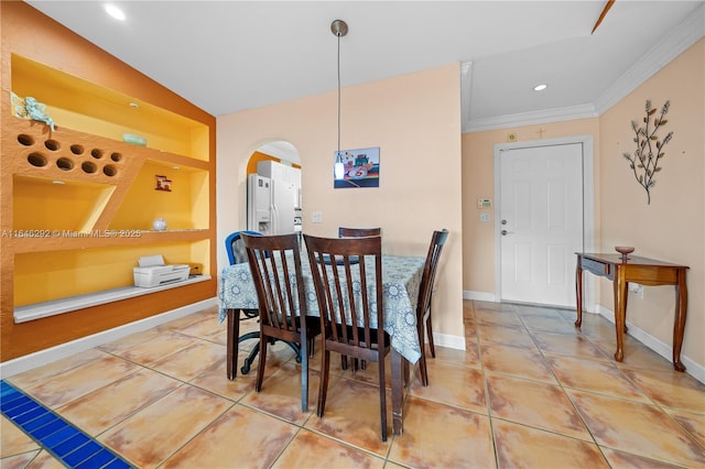 tiled dining room featuring ornamental molding and built in features