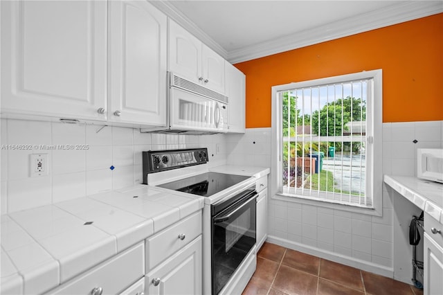 kitchen featuring range with electric cooktop, white cabinetry, tile counters, and dark tile patterned floors