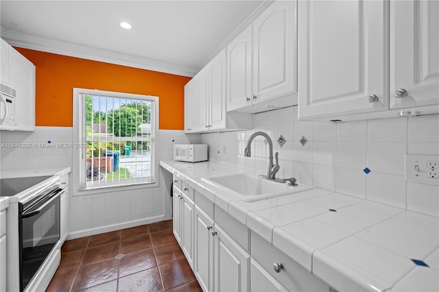 kitchen featuring sink, white appliances, tile countertops, and white cabinets