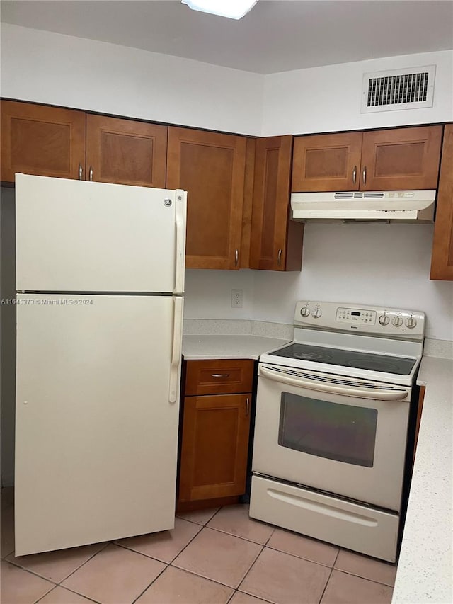 kitchen with white appliances and light tile patterned flooring