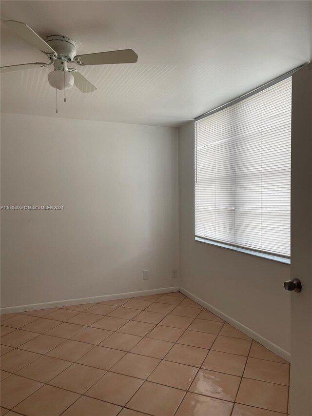 empty room featuring ceiling fan and light tile patterned flooring