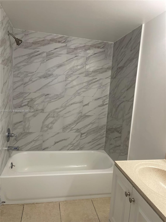 bathroom featuring tile patterned flooring, vanity, and tiled shower / bath combo