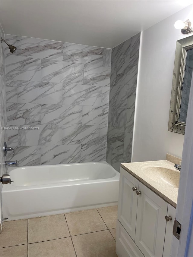 bathroom with tile patterned flooring, tiled shower / bath, and vanity