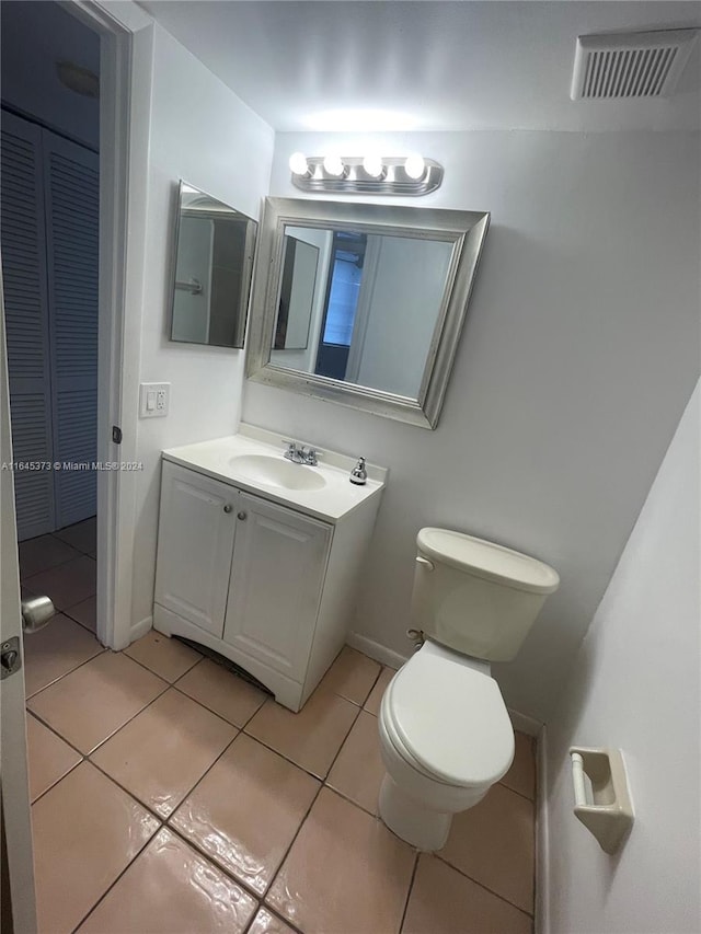 bathroom with toilet, tile patterned flooring, and vanity