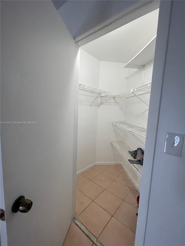 walk in closet with light tile patterned flooring