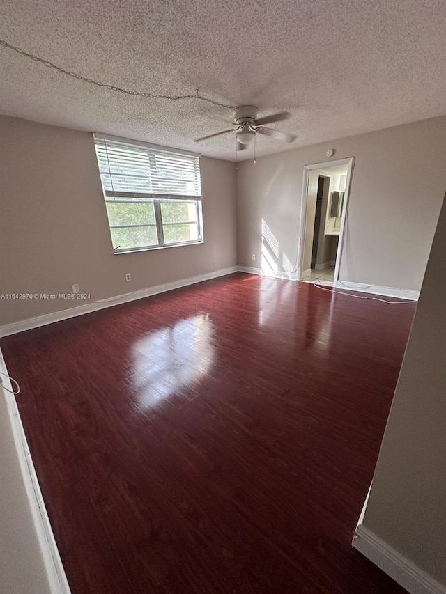 unfurnished room with wood finished floors, a textured ceiling, baseboards, and ceiling fan