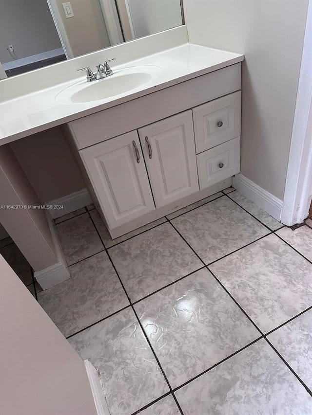 bathroom with baseboards, vanity, and tile patterned flooring