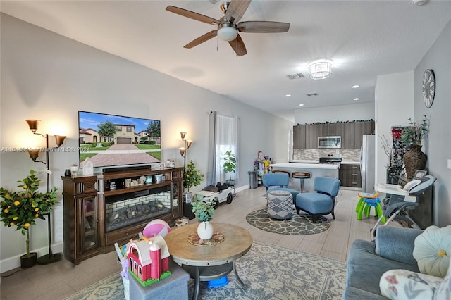 living room featuring ceiling fan and light tile patterned flooring